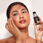 Model dabbing 3 dots of 111SKIN Eye Cream on her under eye whilst holding the glass bottle.
