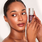 Model looking to the right while holding a bottle of 111skin Eye Gel